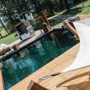 Auf diesem Bild ist ein von uns abgedichteter Koi Teich zusehen, rundherum ist eine Holzterrasse.