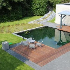 Auf diesem Bild ist ein von uns abgedichteter Koi Teich zusehen, rundherum ist eine Holzterrasse.