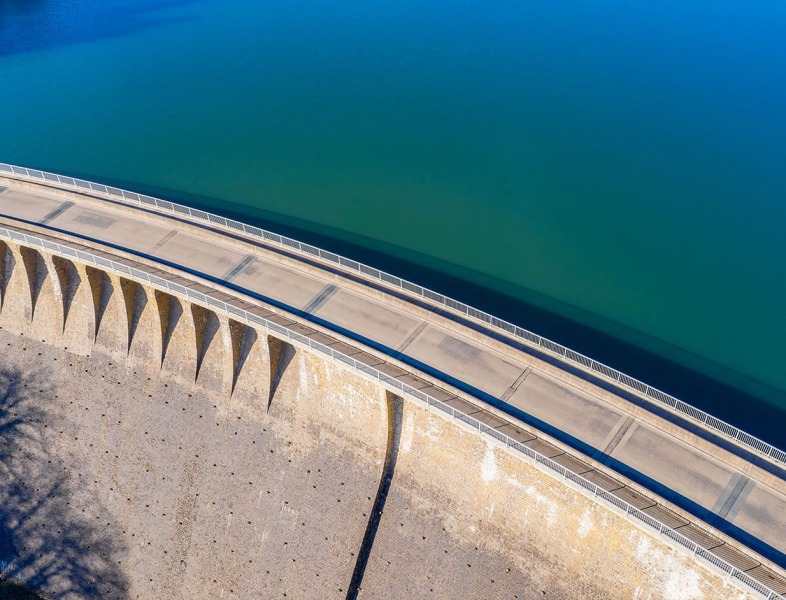 Auf diesem Bild ist ein großer Staudamm zusehen, auf einer Seite sieht man das Wasser und auf der anderen Seite den Damm. Dieser dient als Beispiel für unsere Staudammabdichtung und Kanalabdichtung.